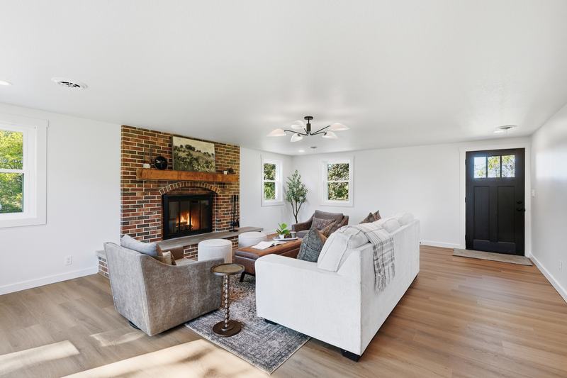 Living room with a brick fireplace, white sofa and luxury vinyl plank floors
